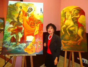 La pittrice Caterina Parrello con i suoi dipinti raffiguranti i compatroni di Calatabiano San Filippo e San Giorgio