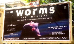 Il poster pubblicitario del musical WORMS per le strade di Palermo