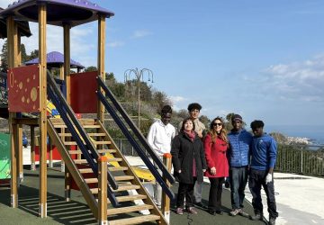 Acireale, villa Belvedere: migranti ripuliscono il parco giochi dalle scritte vandaliche
